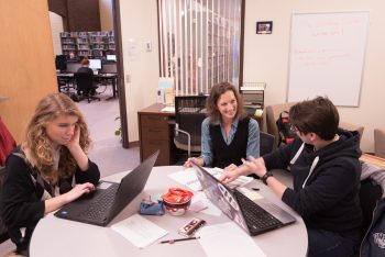 three writers in conversation around circular table